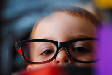 Young Boy playing with glasses on
