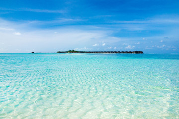 Beautiful tropical Maldives island with beach. Sea with water bungalows