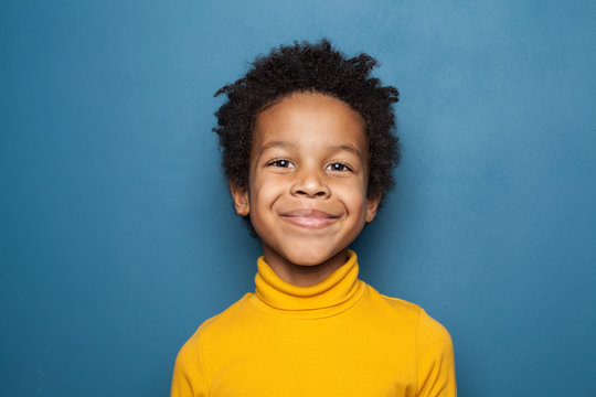 Happy child portrait. Little african american kid boy on blue background