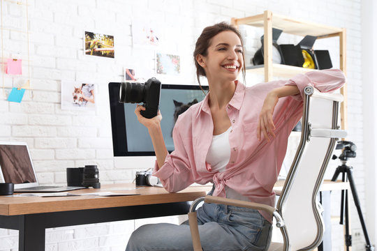 Professional photographer with camera at table in office
