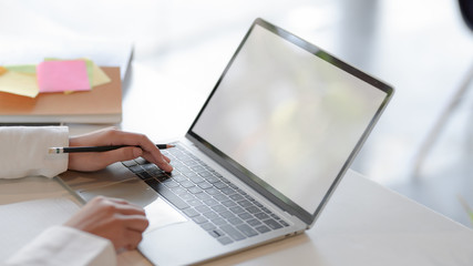 Cropped shot of businesswoman typing on blank screen laptop