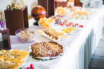 Delicious sweets on wedding candy buffet with desserts, cupcakes