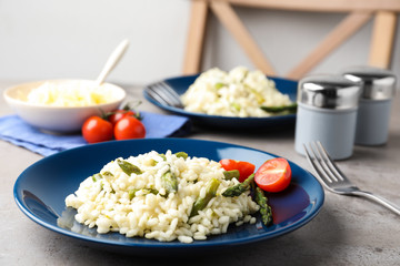 Delicious risotto with asparagus on grey table