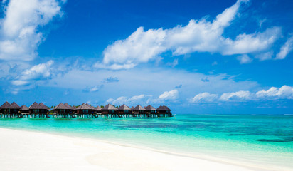 Fototapeta na wymiar Beautiful tropical Maldives island with beach. Sea with water bungalows