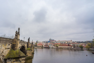 Fototapeta na wymiar Panorama of the Old Town of Prague, Czech Republic, with a focus on Charles bridge (Karluv Most) and the Prague Castle (Prazsky hrad) seen from the Vltava river. The castle is main touristic landmark