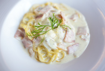 Spaghetti carbonara pasta on white dish.