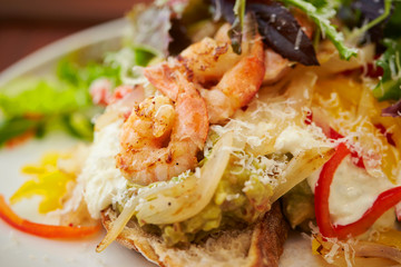 Grilled shrimp salad with tartar sauce and baguette 