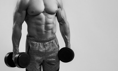 Muscular strong bodybuilder holding dumbbells