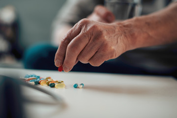 Close up of old man taking pills. Senior man drinking medicine. 