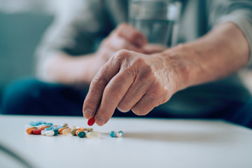 Close up of old man taking pills. Senior man drinking medicine. 