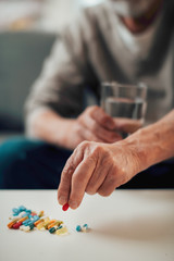 Fototapeta na wymiar Close up of old man taking pills. Senior man drinking medicine. 