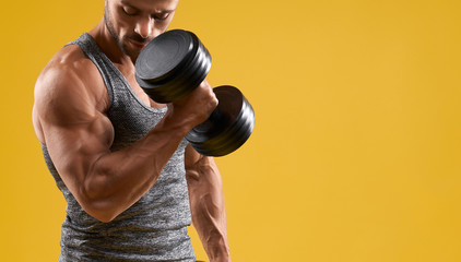 Handsome bodybuilder doing exercise with dumbbell