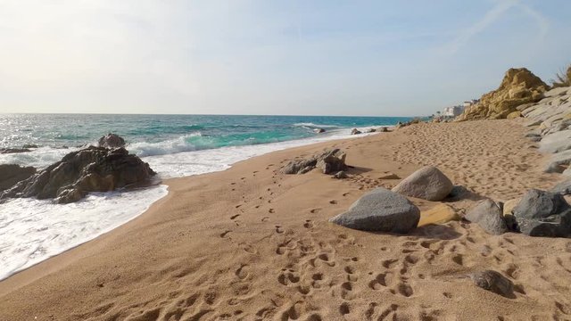 beautiful mediterranean sand beach ,maresme barcelona, san pol de mar, with rocks and calm sea and turquoise , costa brava , calella de mar