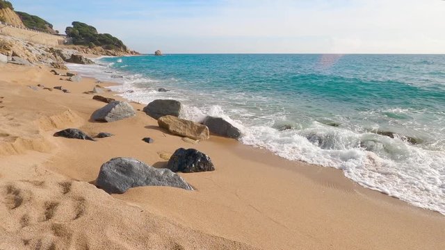 beautiful mediterranean sand beach ,maresme barcelona, san pol de mar, with rocks and calm sea and turquoise , costa brava, calella de mar