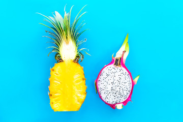 Two 2 halves of ripe yellow pineapple, ananas and dragon fruit, pitaya or pitahaya, cactus. Cut in...