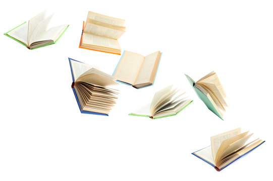 Colorful hardcover books flying on white background