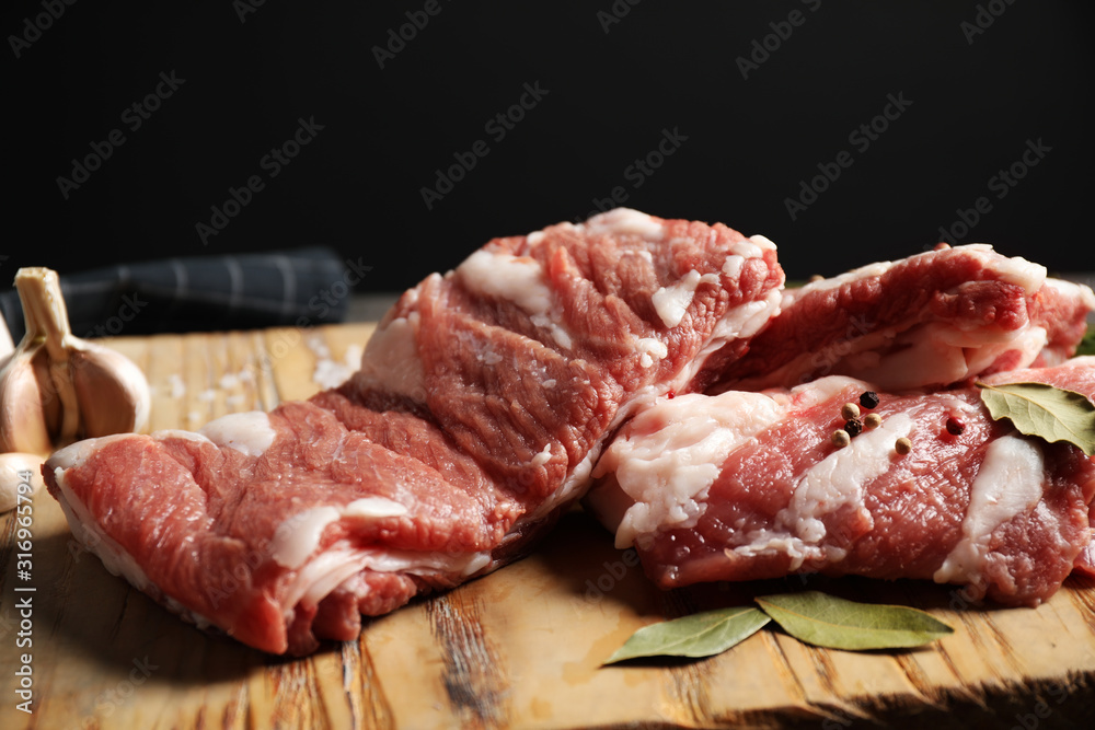 Wall mural raw ribs with bay leaves and salt on wooden board, closeup