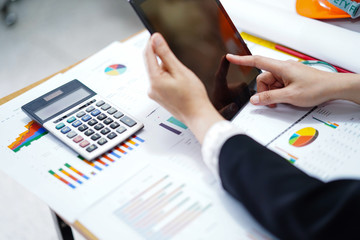 Accounting press tablet with calculator and chart graph for working project in modern office.