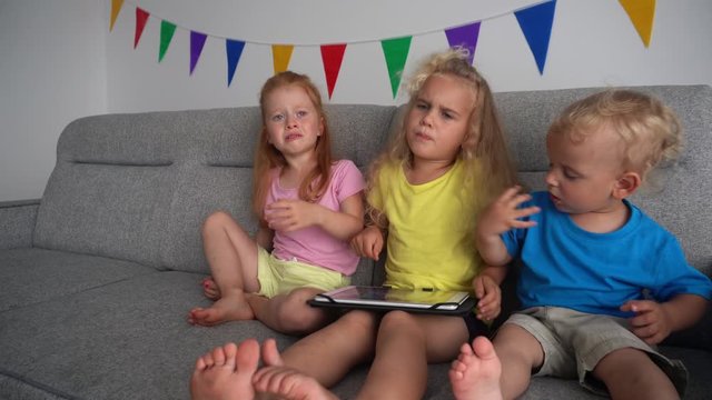 Angry addictive children fight for playing with tablet computer. camera motion