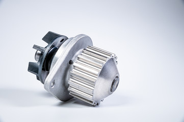 New metal automobile pump for cooling the engine of a water pump on a gray background. The concept of new spare parts for the car engine