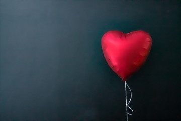 Red air balloons in the shape of a heart on a black background. valentines day, love.