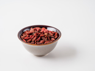 Goji berry isolated on white background in the plate.