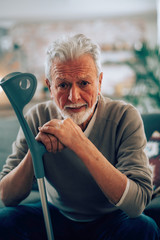 Old man with crutches. Senior man having pain.