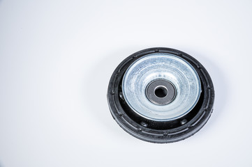 New thrust bearing of front suspension strut of a car on a gray background. The concept of new spare parts and replacement parts in service centers