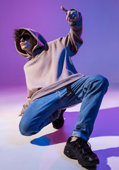 Breakdancing young man in hoodie with hair styling. Dance school poster. Copy space. Battle...