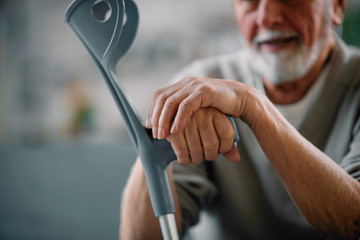 Old man with crutches. Senior man having pain.
