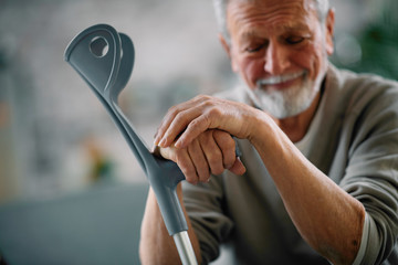 Old man with crutches. Senior man having pain.