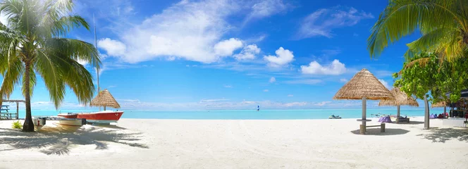 Fototapeten Panorama schöner Strand mit weißem Sand, türkisfarbenem Meer und blauem Himmel mit Wolken an einem sonnigen Tag. Tropische Sommerlandschaft mit grünen Palmen und Strohschirmen mit leerem Kopienraum. © Laura Pashkevich