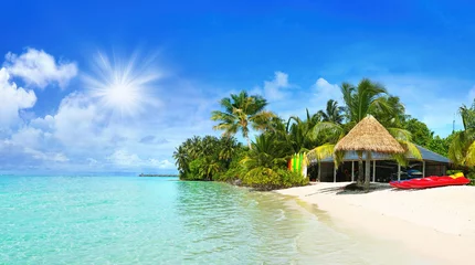 Schöner Strand mit weißem Sand, türkisfarbenem Meer und blauem Himmel mit Wolken an sonnigen Tagen. Tropische Sommerlandschaft mit grünen Palmen und Strohschirmen. © Laura Pashkevich