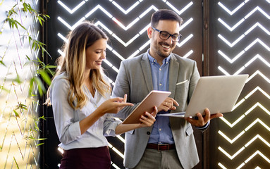 Business colleagues laughing and working while looking at the laptop