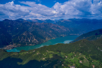 Panoramic view of the mountains and Lake Idro.  Reflection in the water of the mountains, trees, blue sky. Aerial view, drone photo