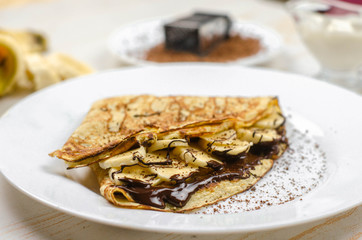 Homemade thin pancakes made with oat flour, banana, chocolate and nuts. Healthy food, proper nutrition breakfast