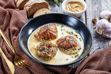 rabbit ballotine in a black bowl, close-up