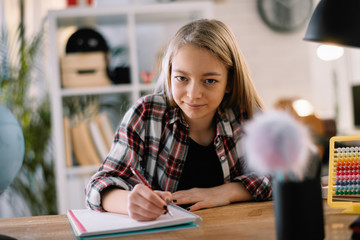 Young girl doing homework. Beautiful little girl at home learning 