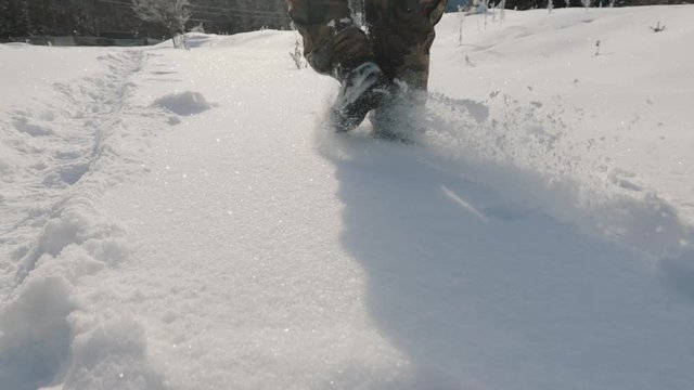 hunter walks through snow-capped mountains