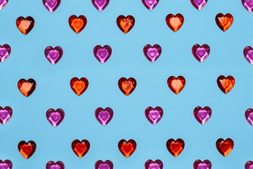 Red and pink glass hearts on a blue staggered background. 