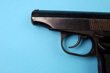 Black gun lies on a blue background