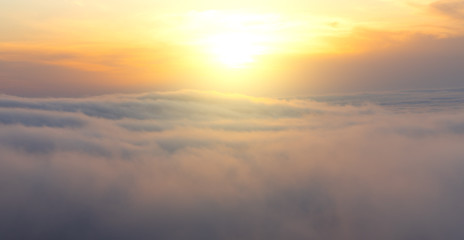 Fototapeta na wymiar Beautiful aerial view from above clouds with sunset. Airplane view.