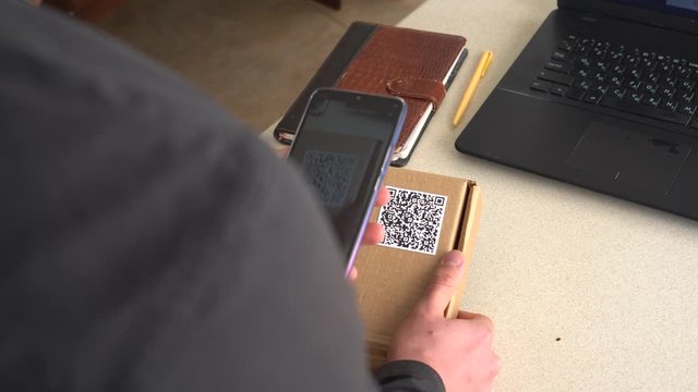 A man scans Qr code for tracking a delivery  - Invoice, Packing Slip, Delivery Note and Shipping Label