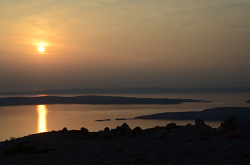 Fototapeta na wymiar Sunset over the mountains in the sea