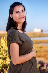 Fototapeta na wymiar Pregnant woman poses on the marshlands.
