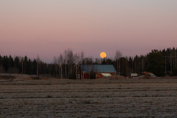 Rural landscape with old house and full moon