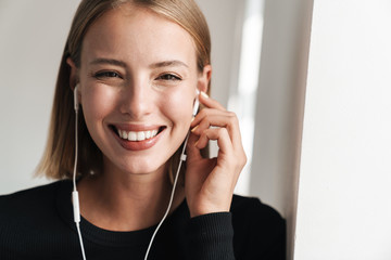 Blonde business woman in office indoors listening music