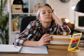 Cute little girl doesn't want to learn. Sad and tired schoolgirl. 