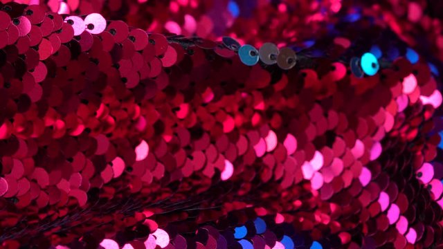 Red and blue sequin fabric. Shiny texture. Background for the holiday. Luxury glamorous fashion, textiles and accessories