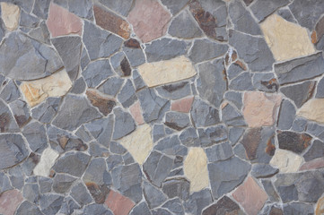 Wall texture of natural chipped stone with cement joints. Decorative stone background. Cobblestone pavement close up.